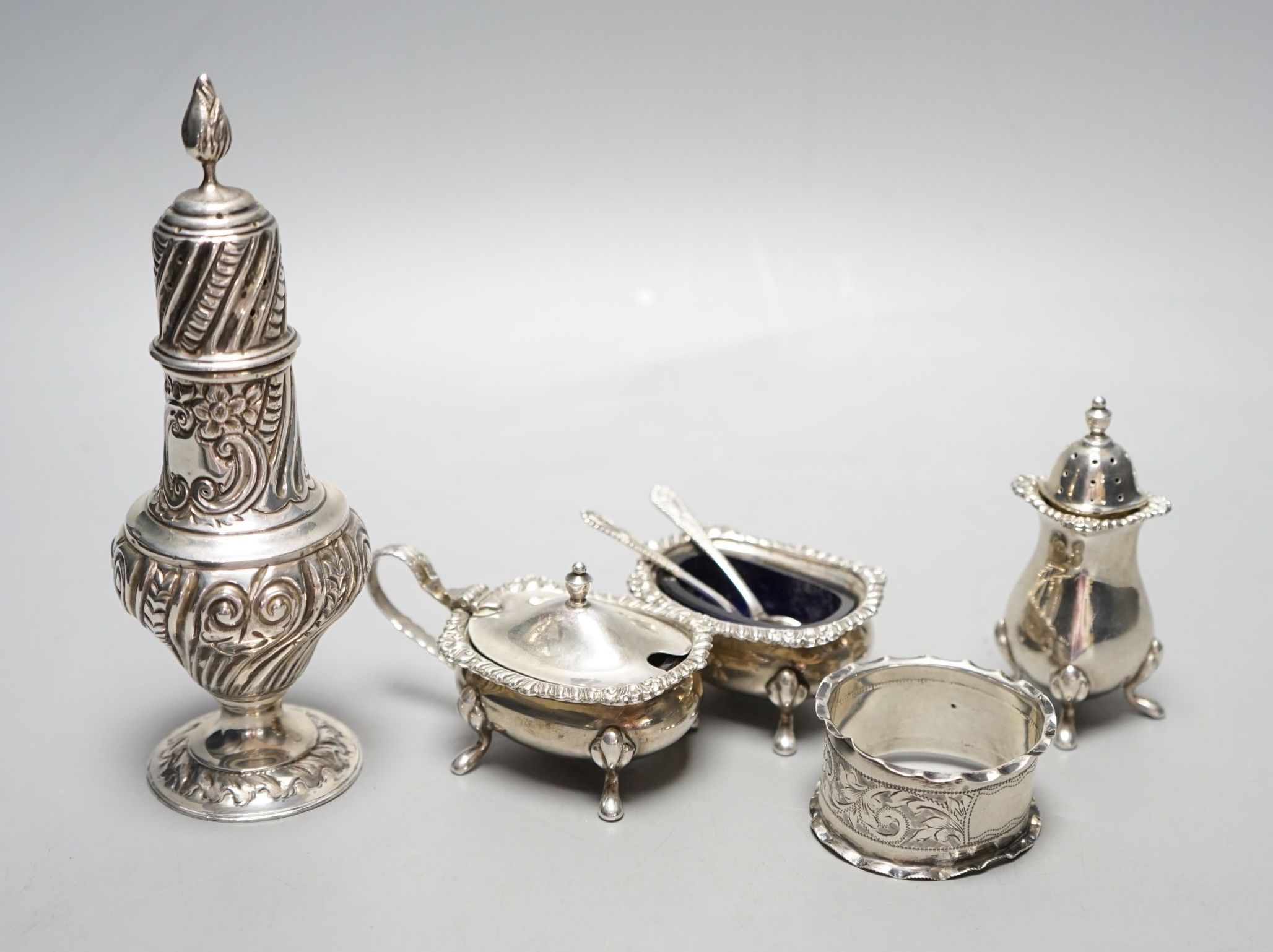 An Edwardian silver sugar sifter, Birmingham, 1901, a silver three piece condiment set and a silver napkin ring.